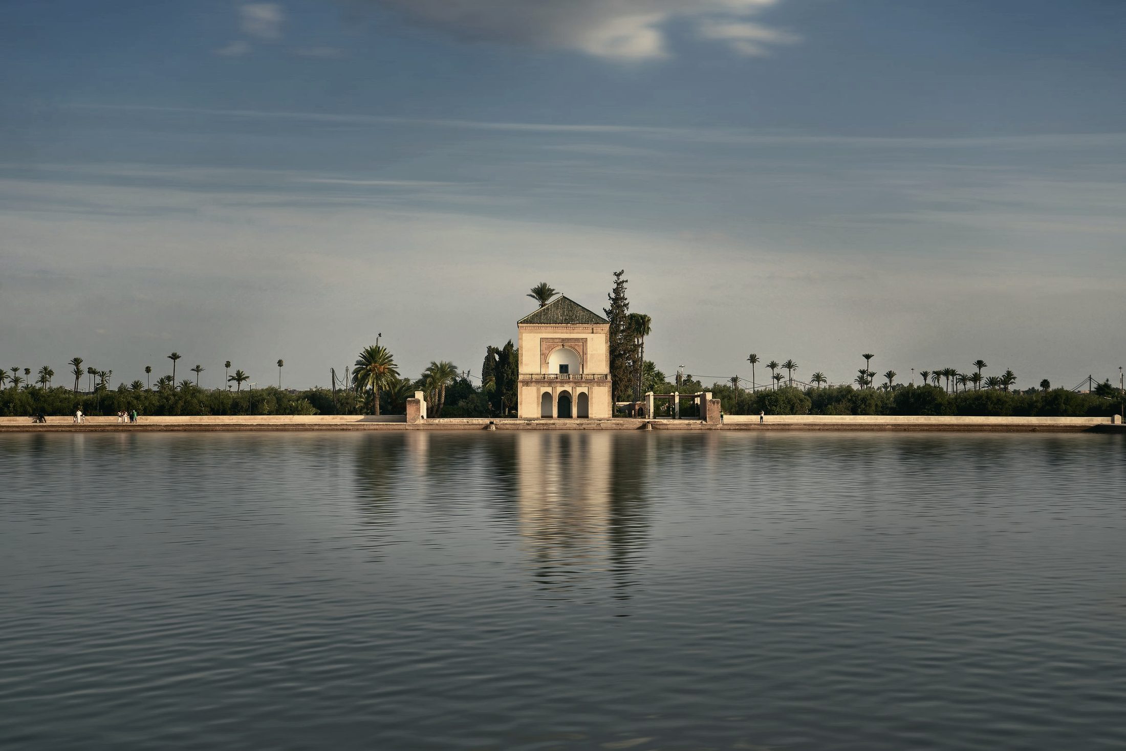 Le pavillon de la Ménara à Marrakech se reflétant dans le grand bassin, la palmeraie en arrière-plan.