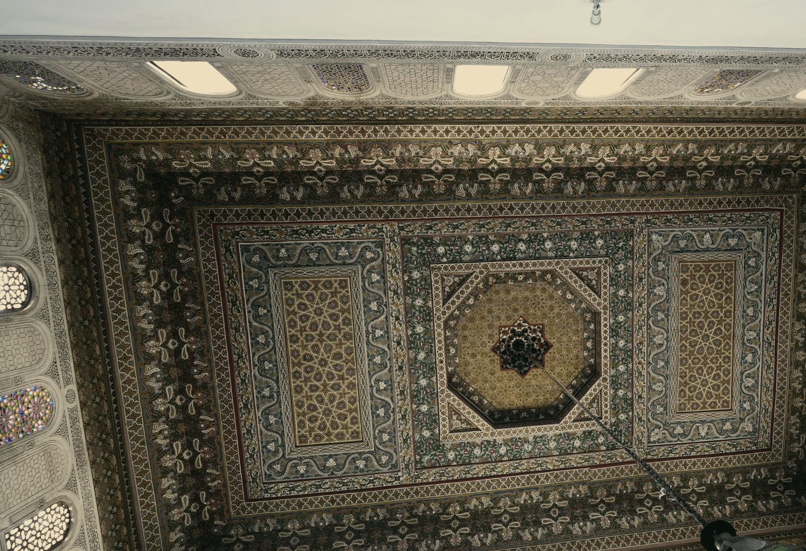 Plafond peint d'un palais de Marrakech : entrelacs géométriques et rosace centrale.